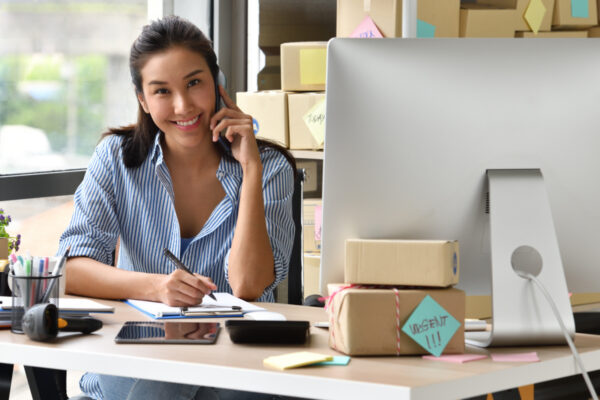 A business owner does work while on the phone.