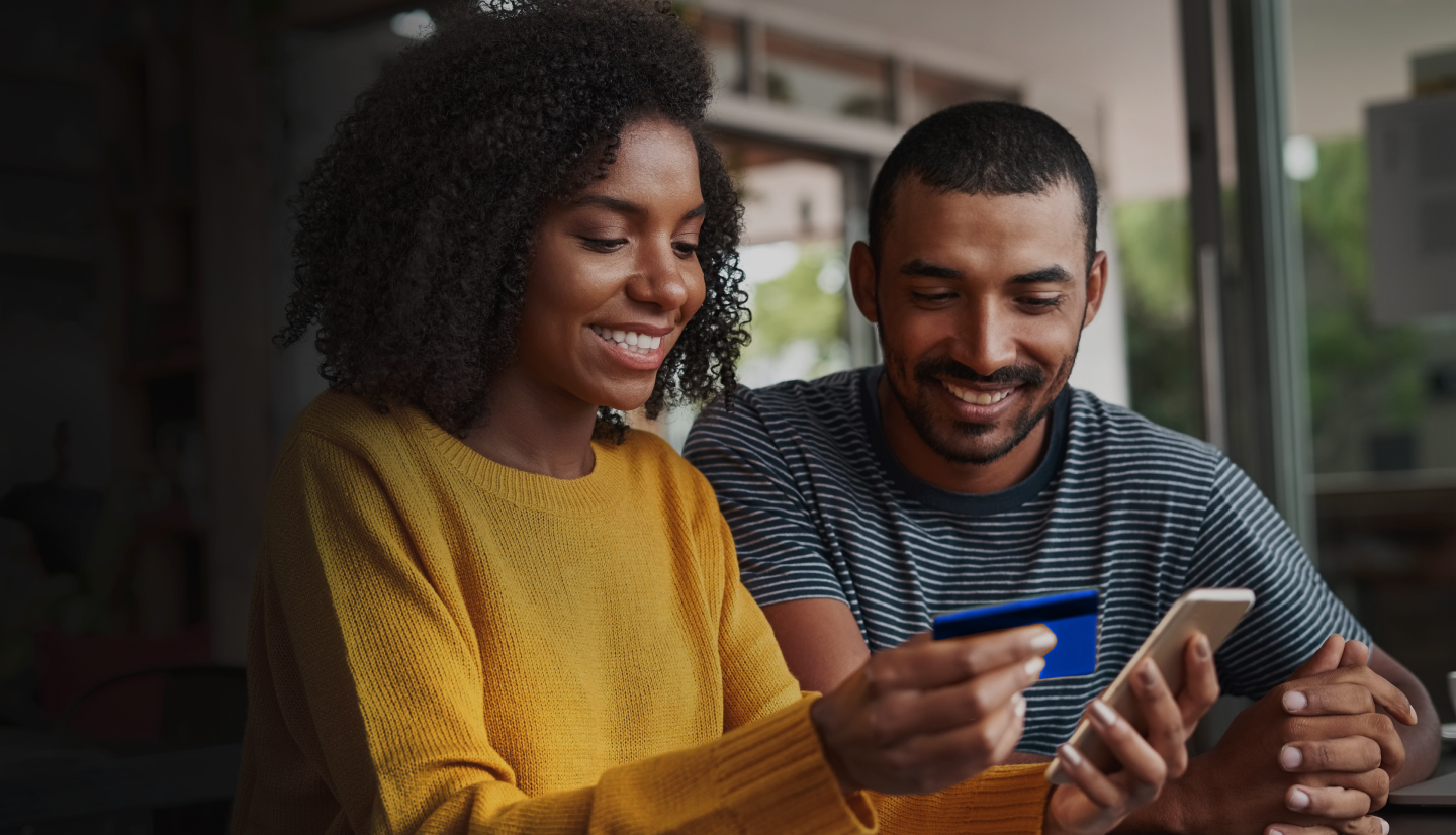 An image of a man and a woman making a purchase on a mobile device with the Hello Alice Small Business Mastercard®