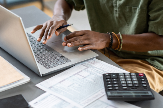 An image of someone working on a laptop at a desk